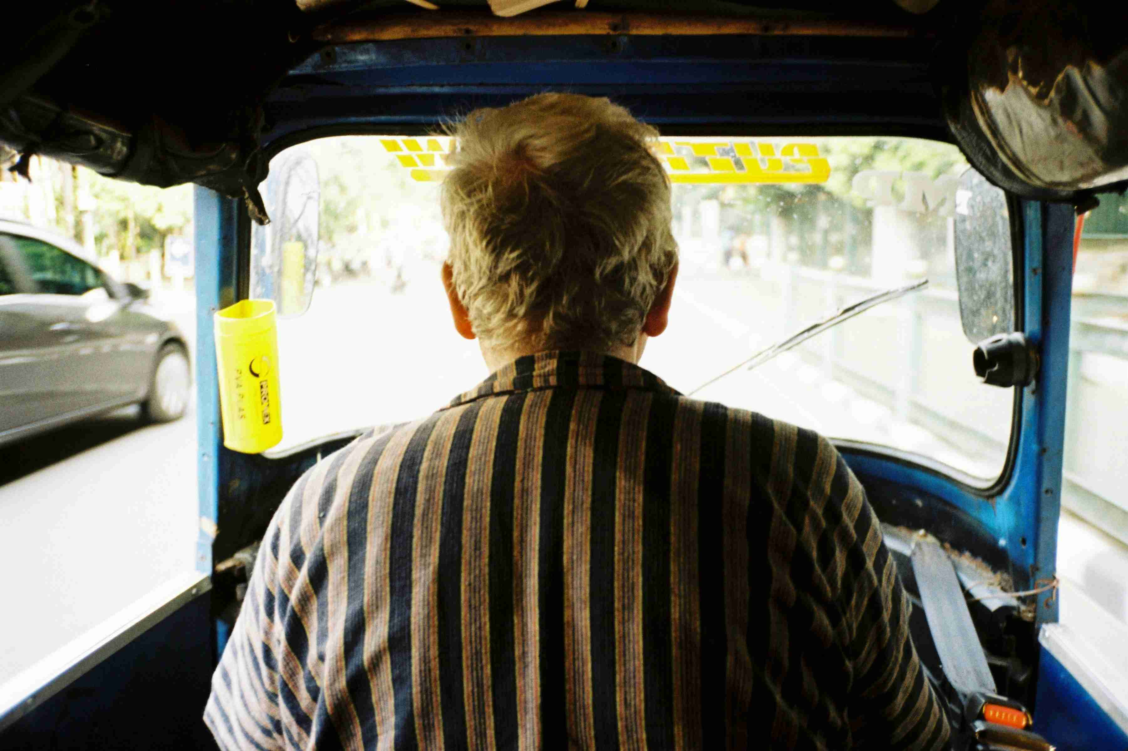 a man driving a blue truck down a street