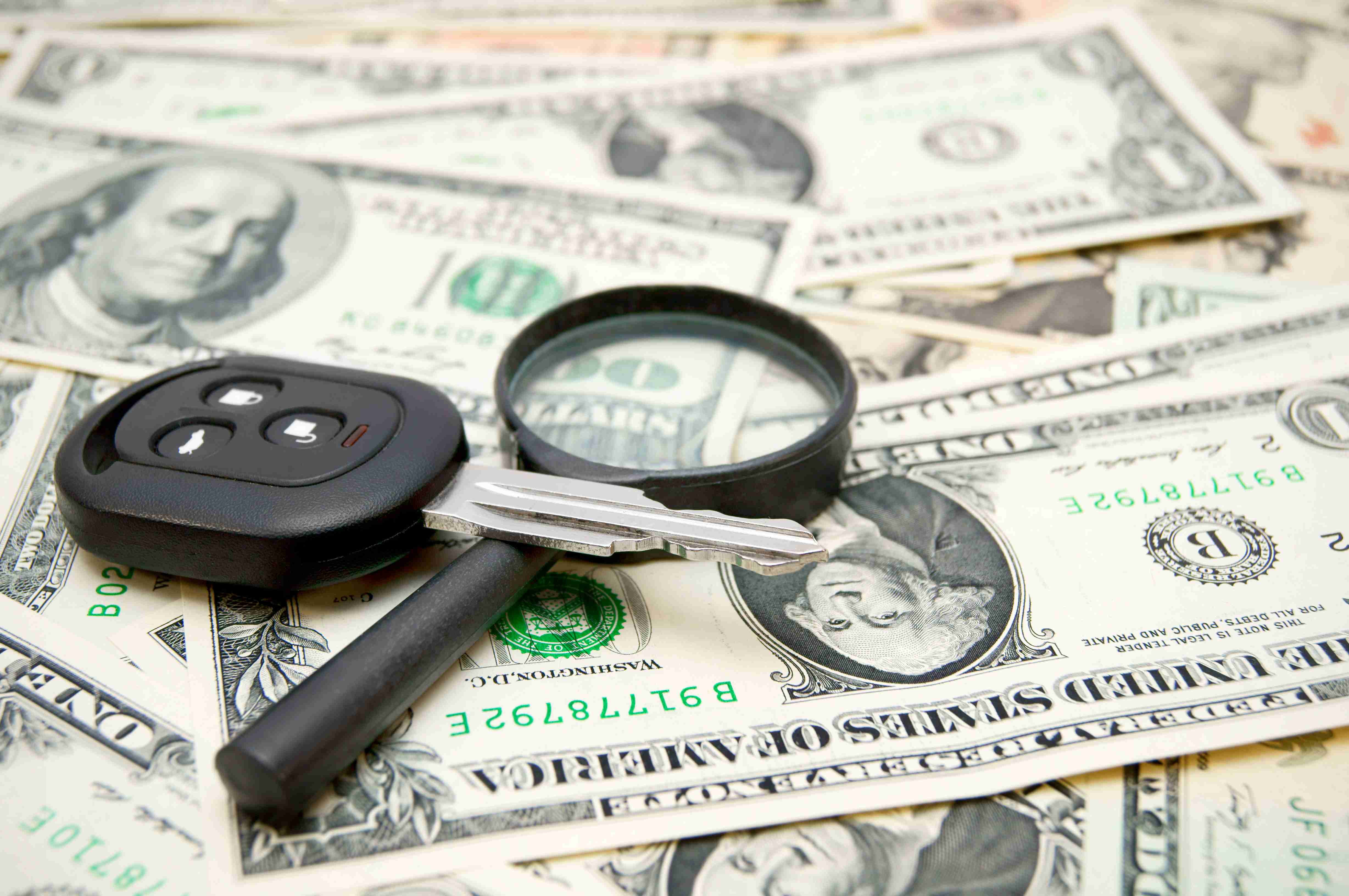 Cheile de la mașină și o lupă pe bani