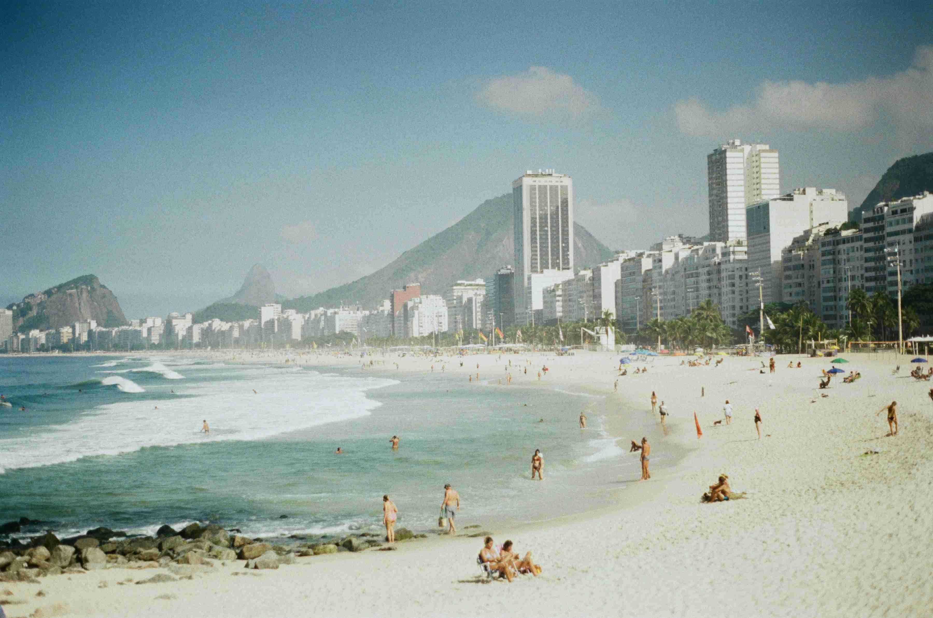 a-crowded-beach-with-a-city-in-the-background