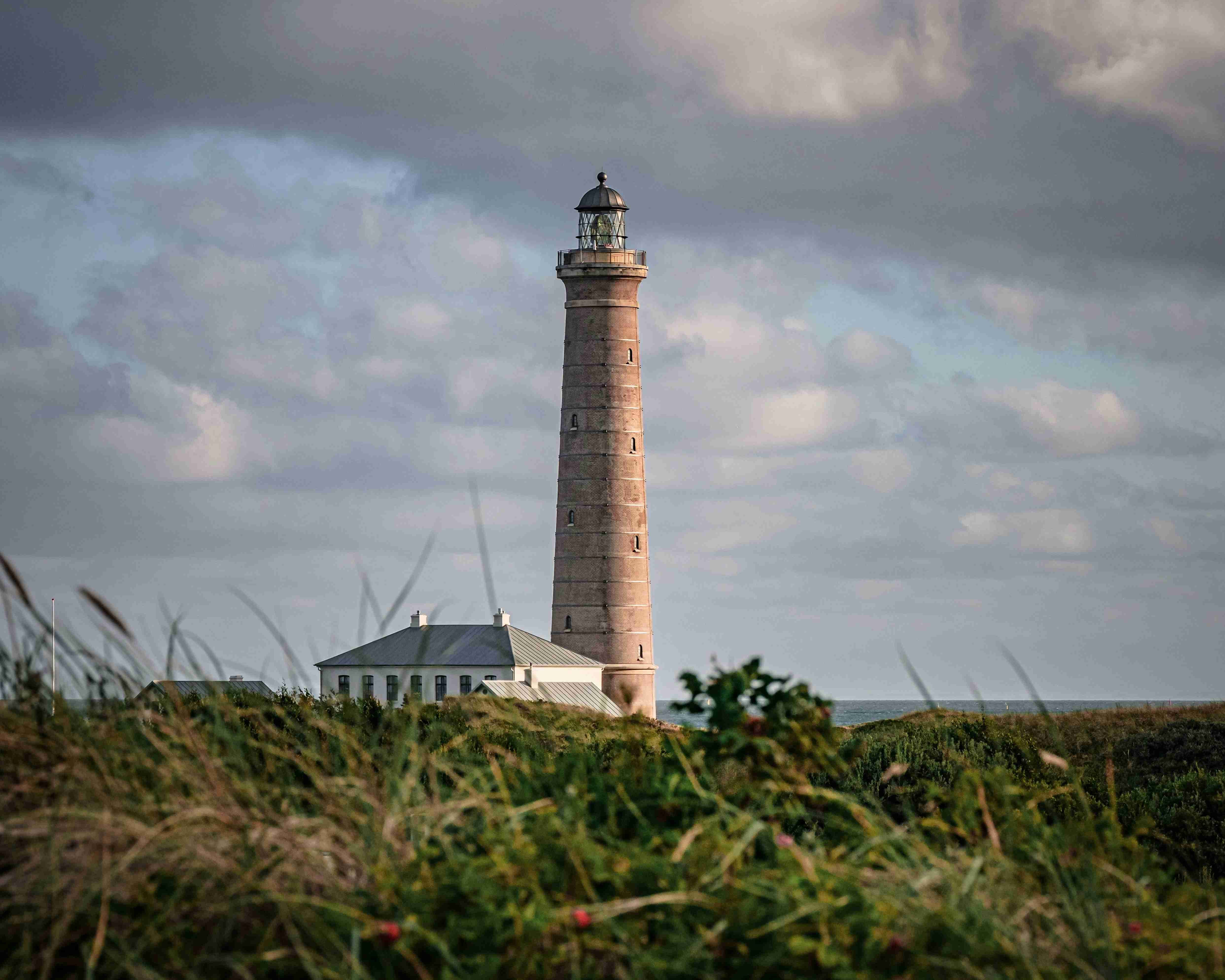 white-and-brown-lighthouse-under-cloudy-sky-during-daytime