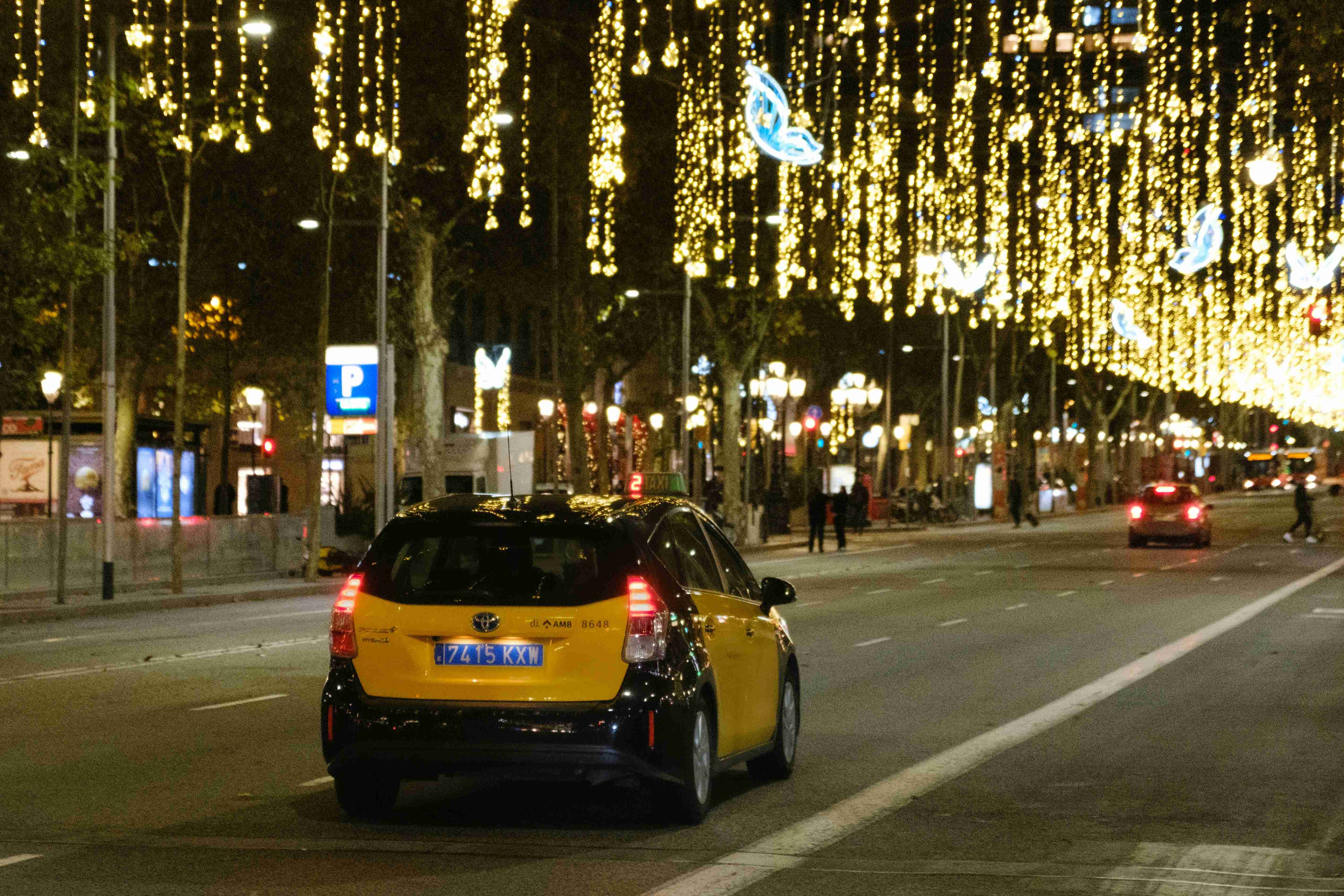 a yellow car driving down a city