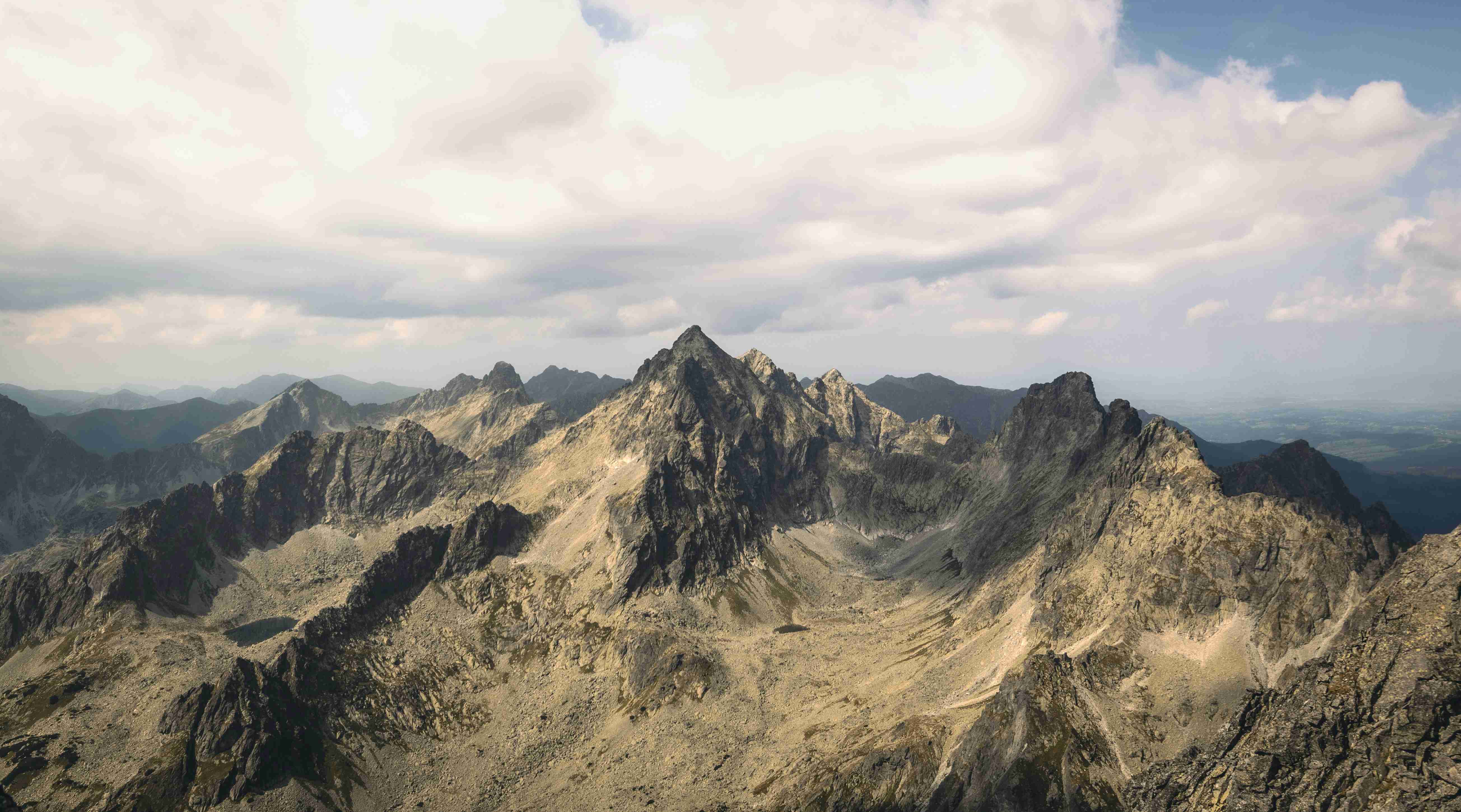 egy hegycsúcsról nyíló kilátás egy hegyláncra