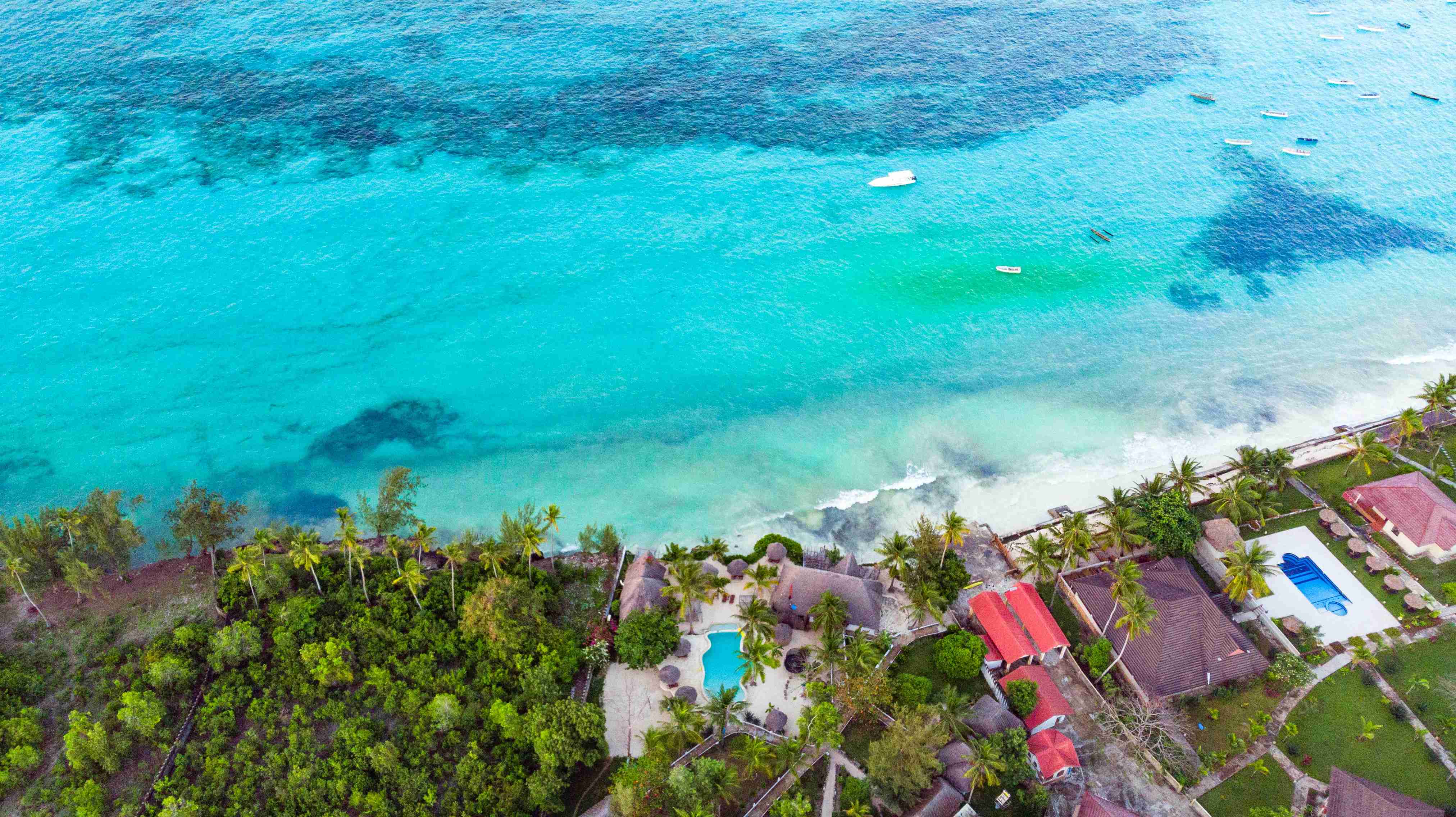 an-aerial-view-of-a-beach-with-a-boat-in-the-water