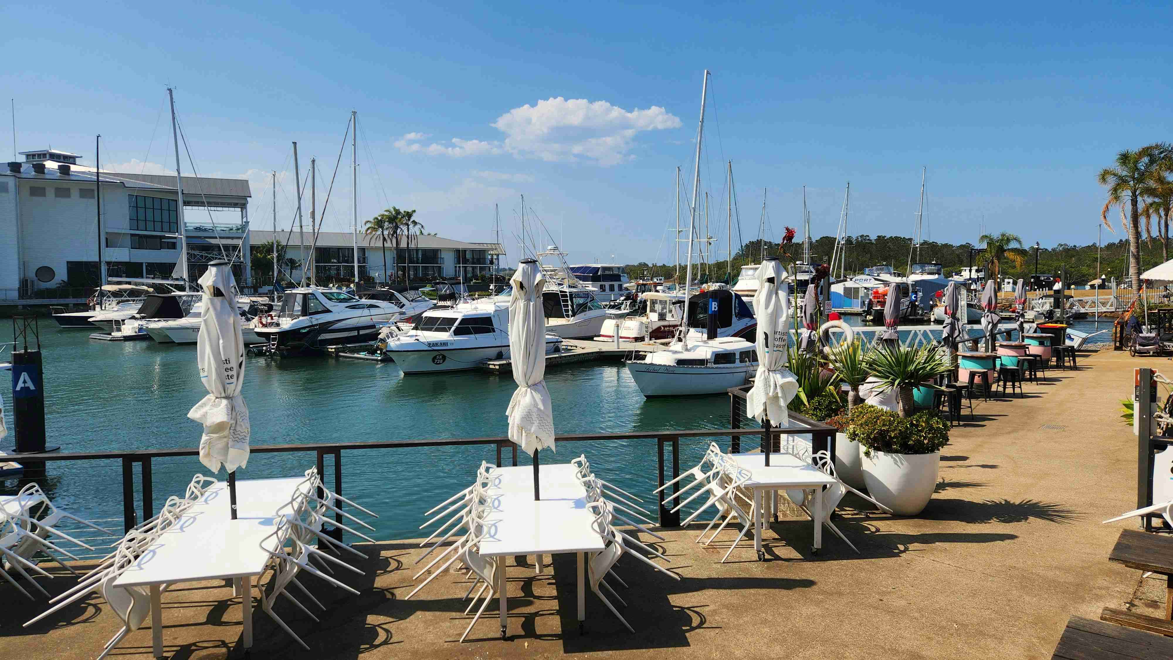 a-marina-filled-with-lots-of-white-tables-and-chairs