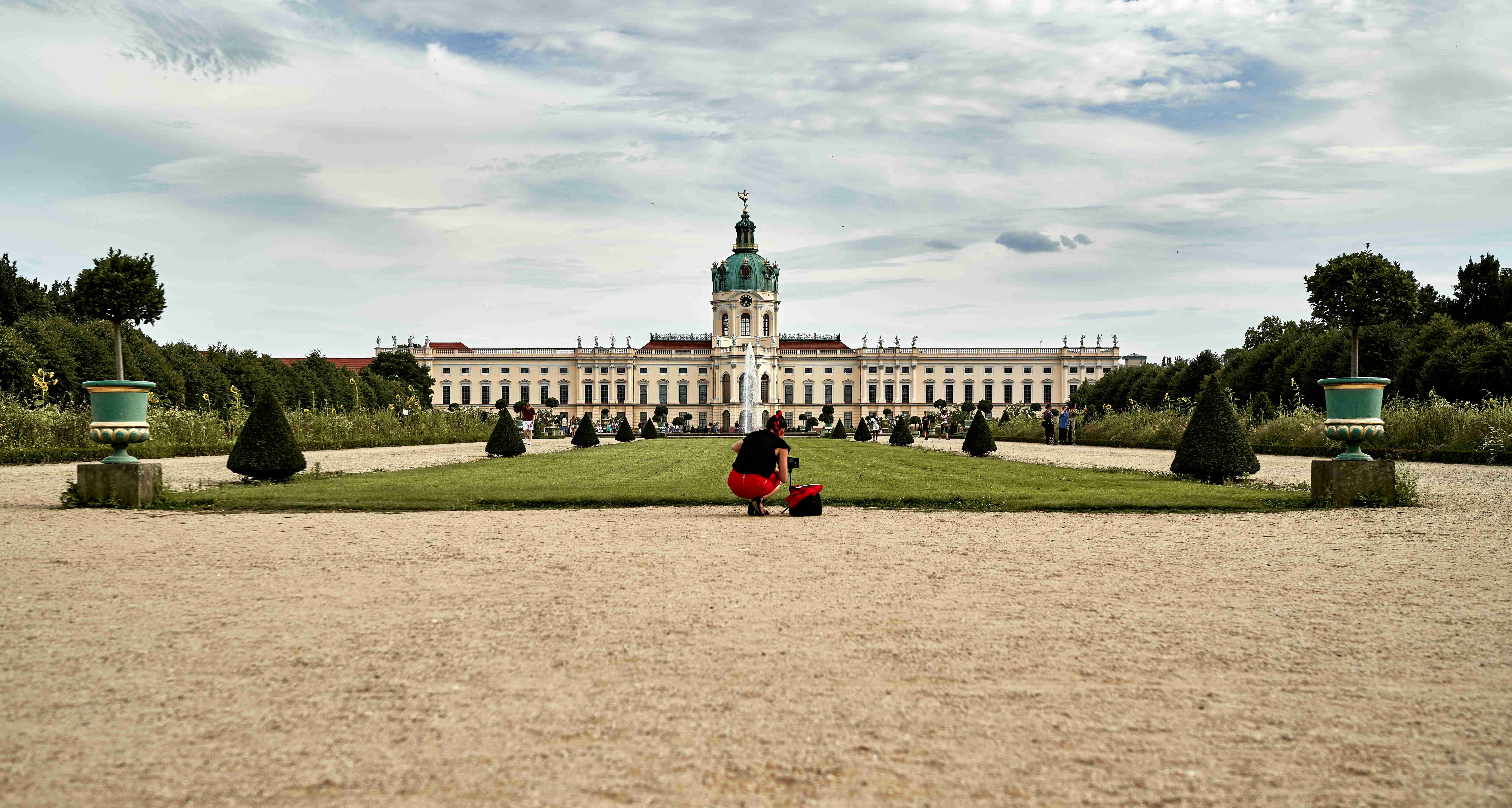 a-person-sitting-on-a-bench-in-front-of-a-large-building