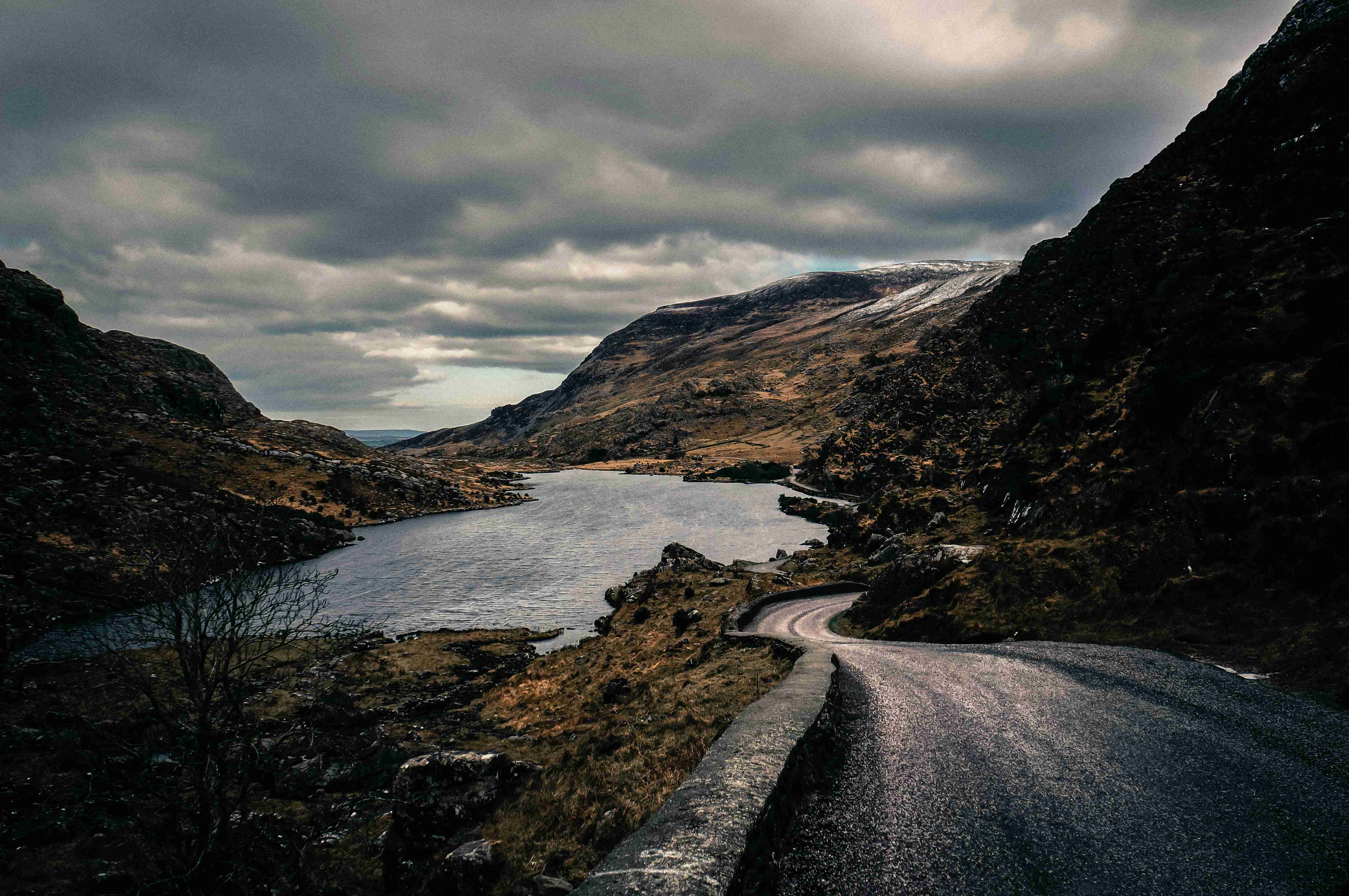 coklat-dan-kelabu-gunung-di-sebelah-badan-air-di bawah-langit-mendung-pada-waktu-siang