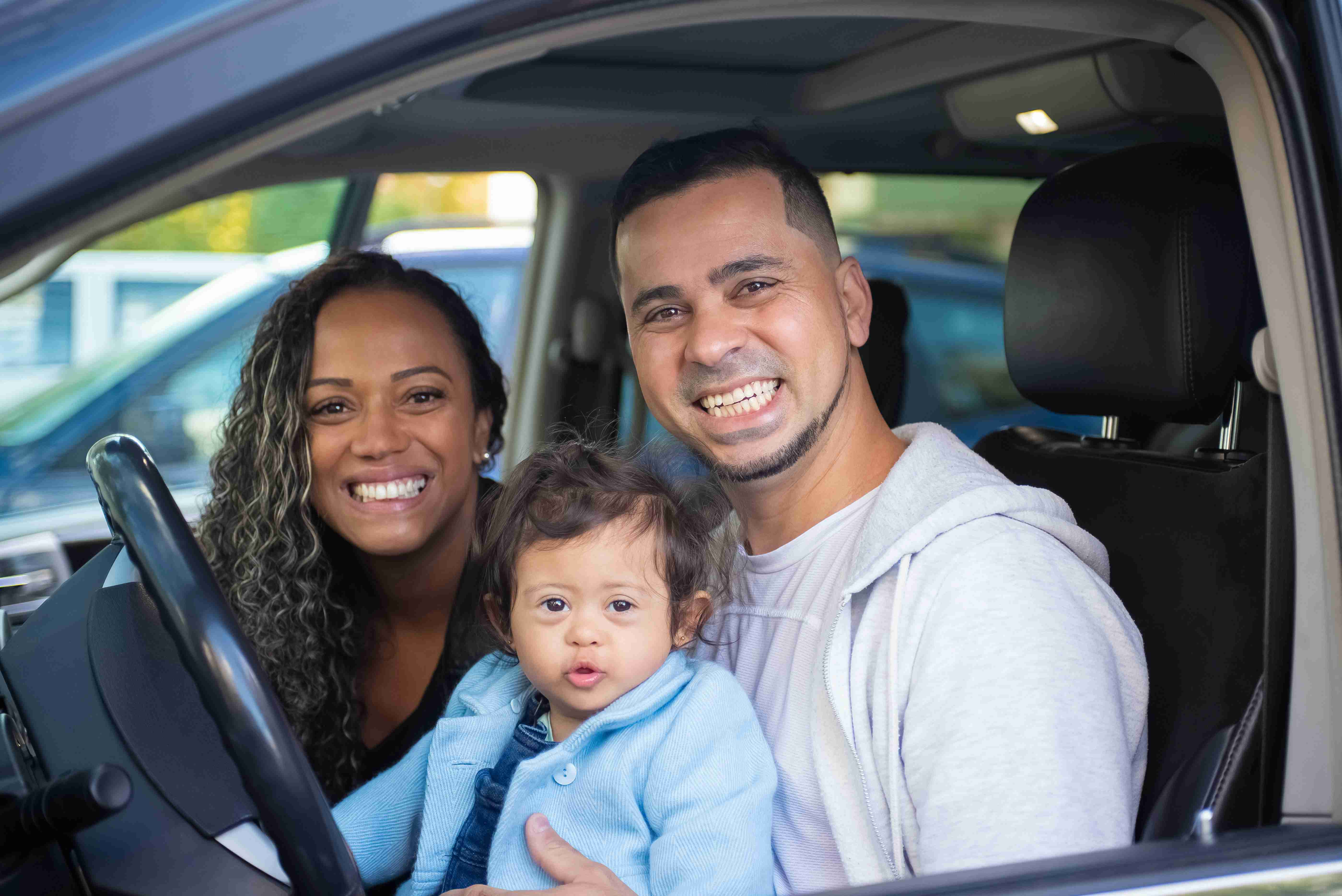 parents inside a car with their child