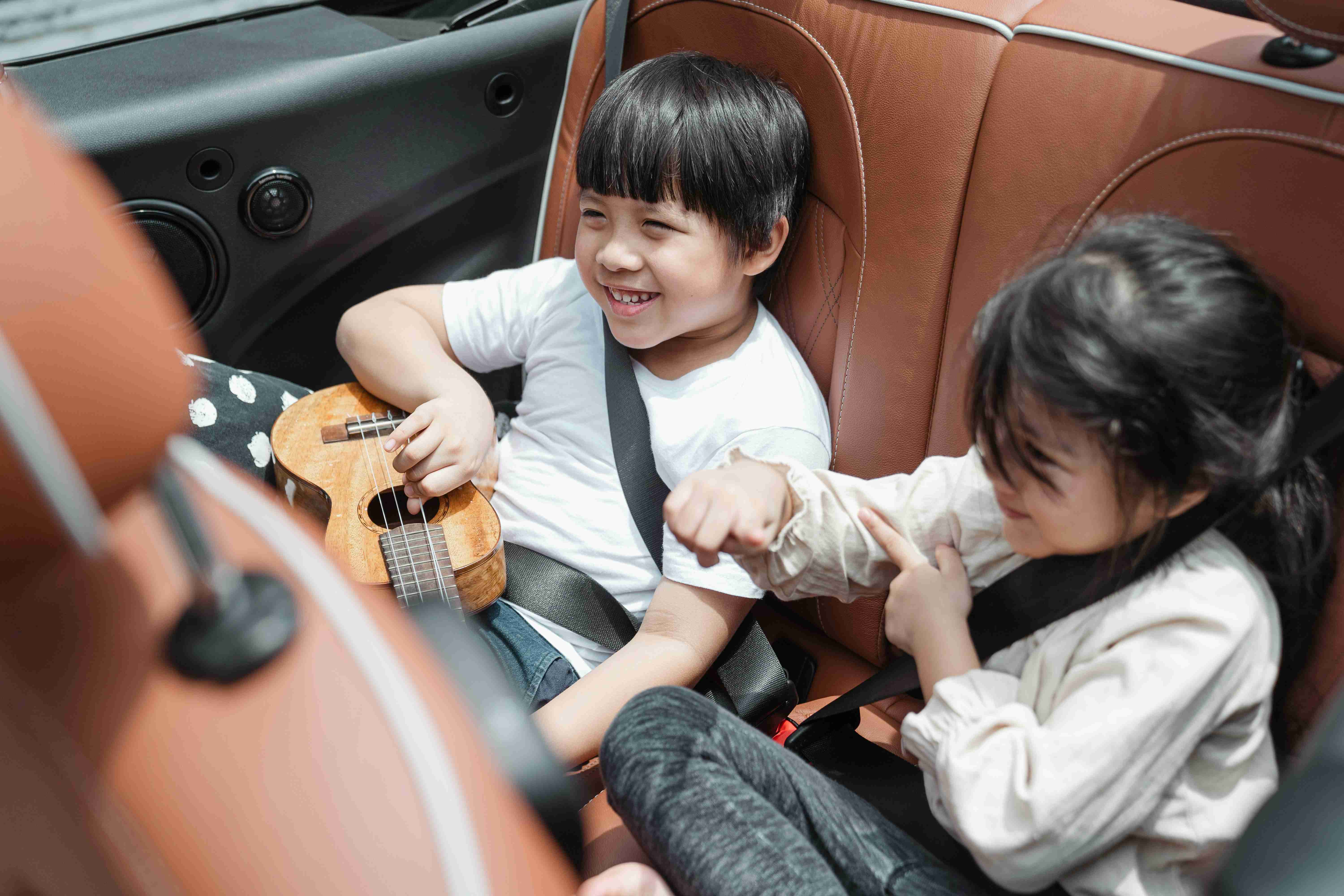 happy-asian-kids-traveling-in-car