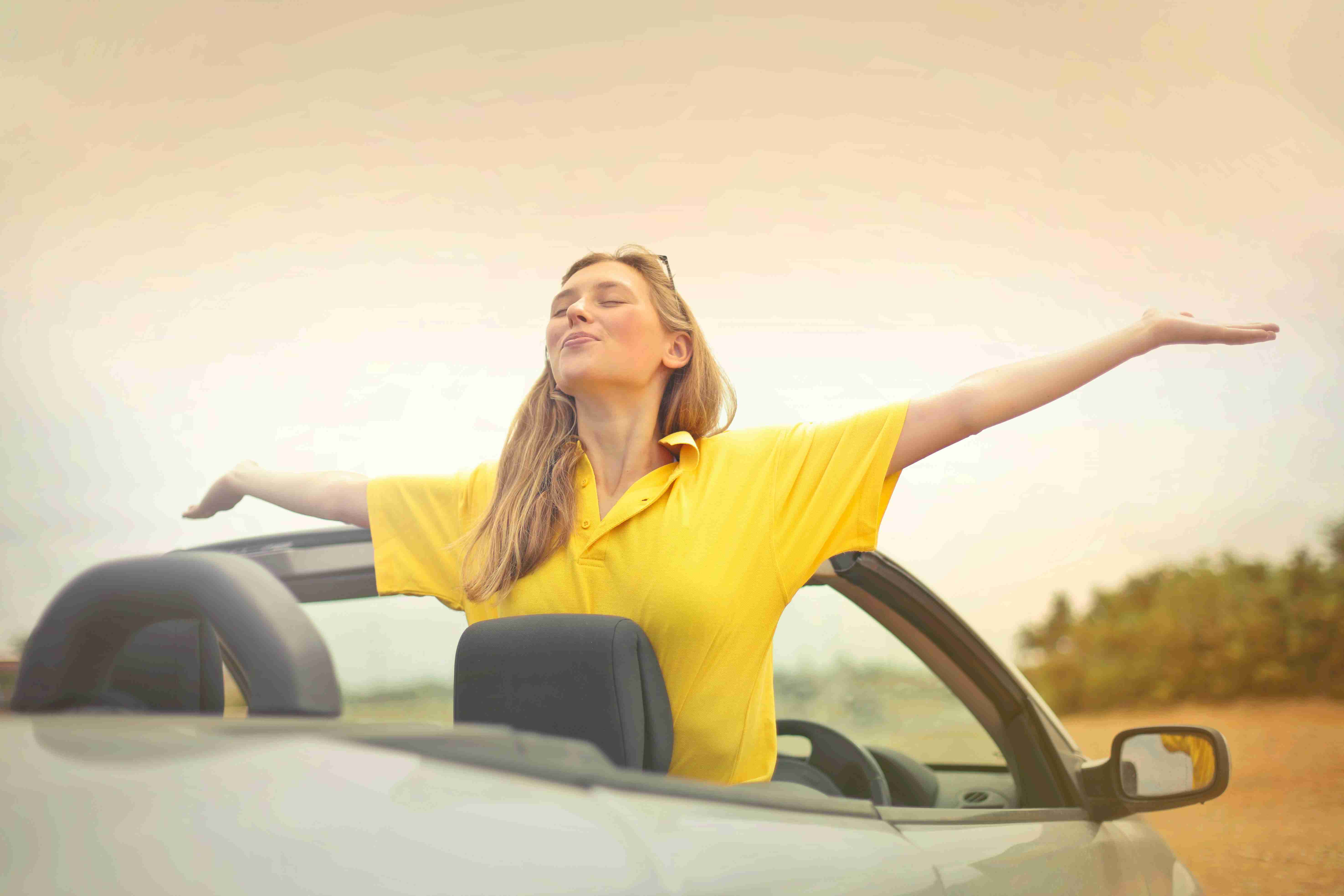 woman-sitting-on-car-under-gray-sky