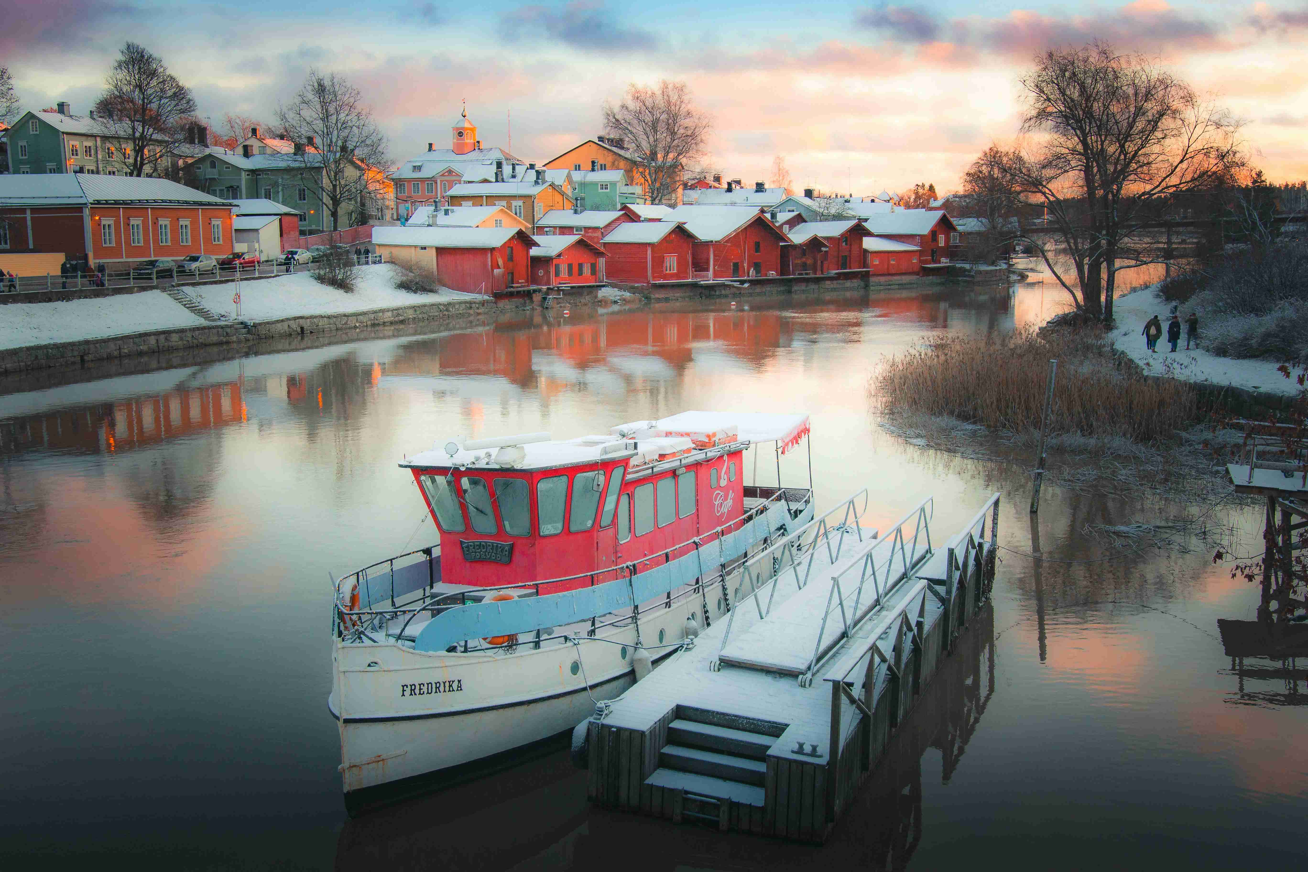 white-boat-on-water-near-houses