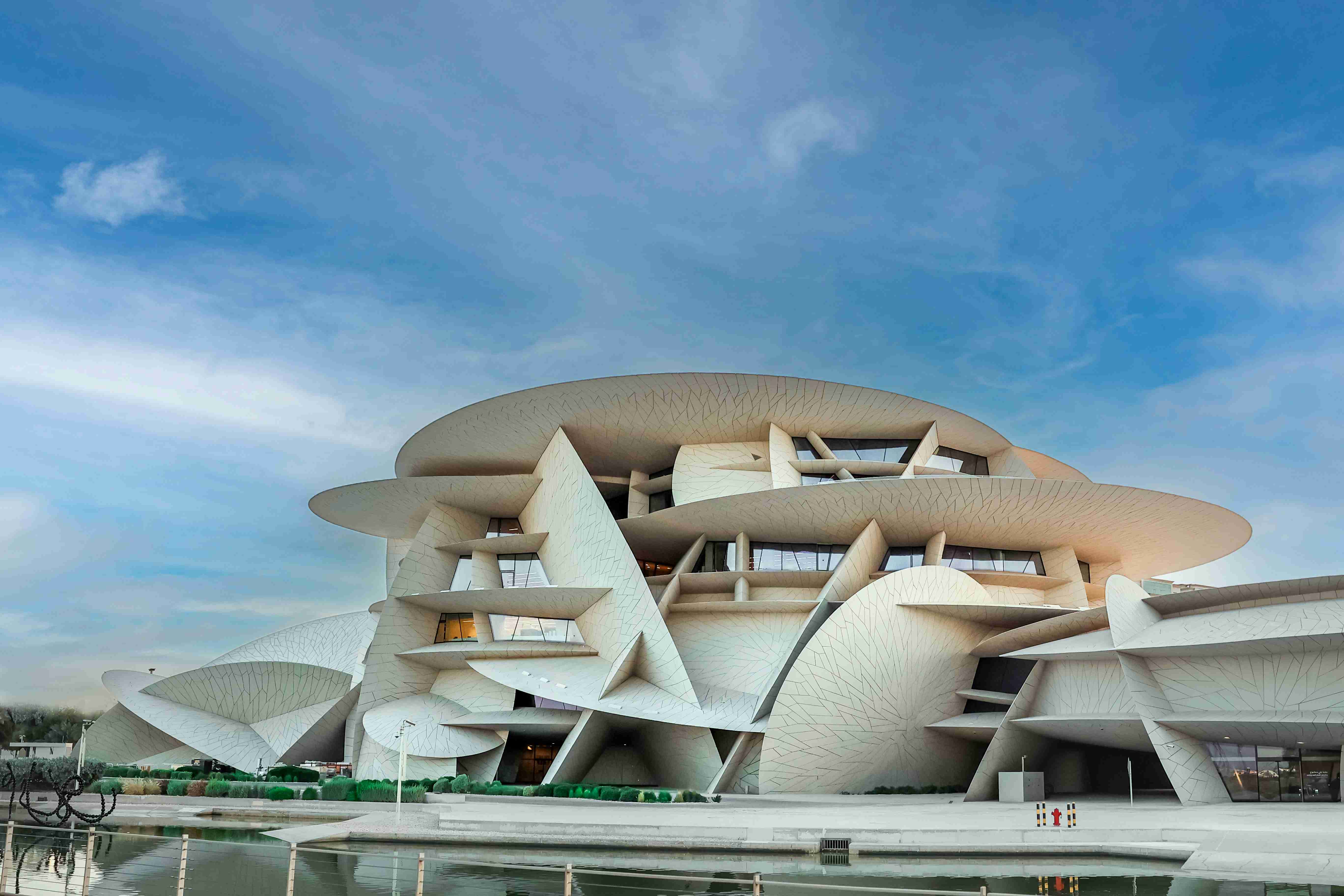 un-grande-edificio-bianco-seduto-accanto-a-uno-specchio-d'acqua