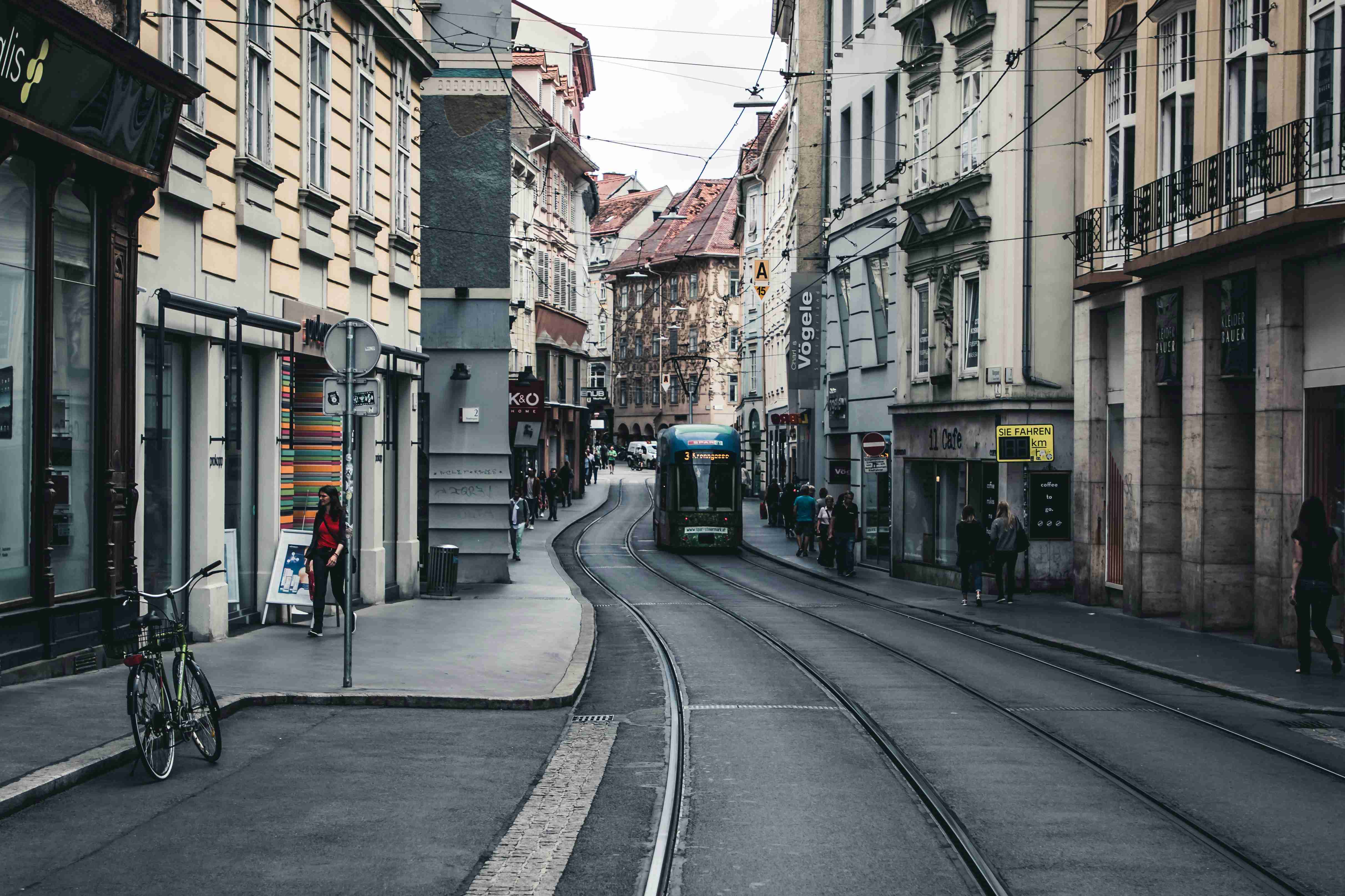 a-narrow-city-street-with-a-train-on-the-tracks