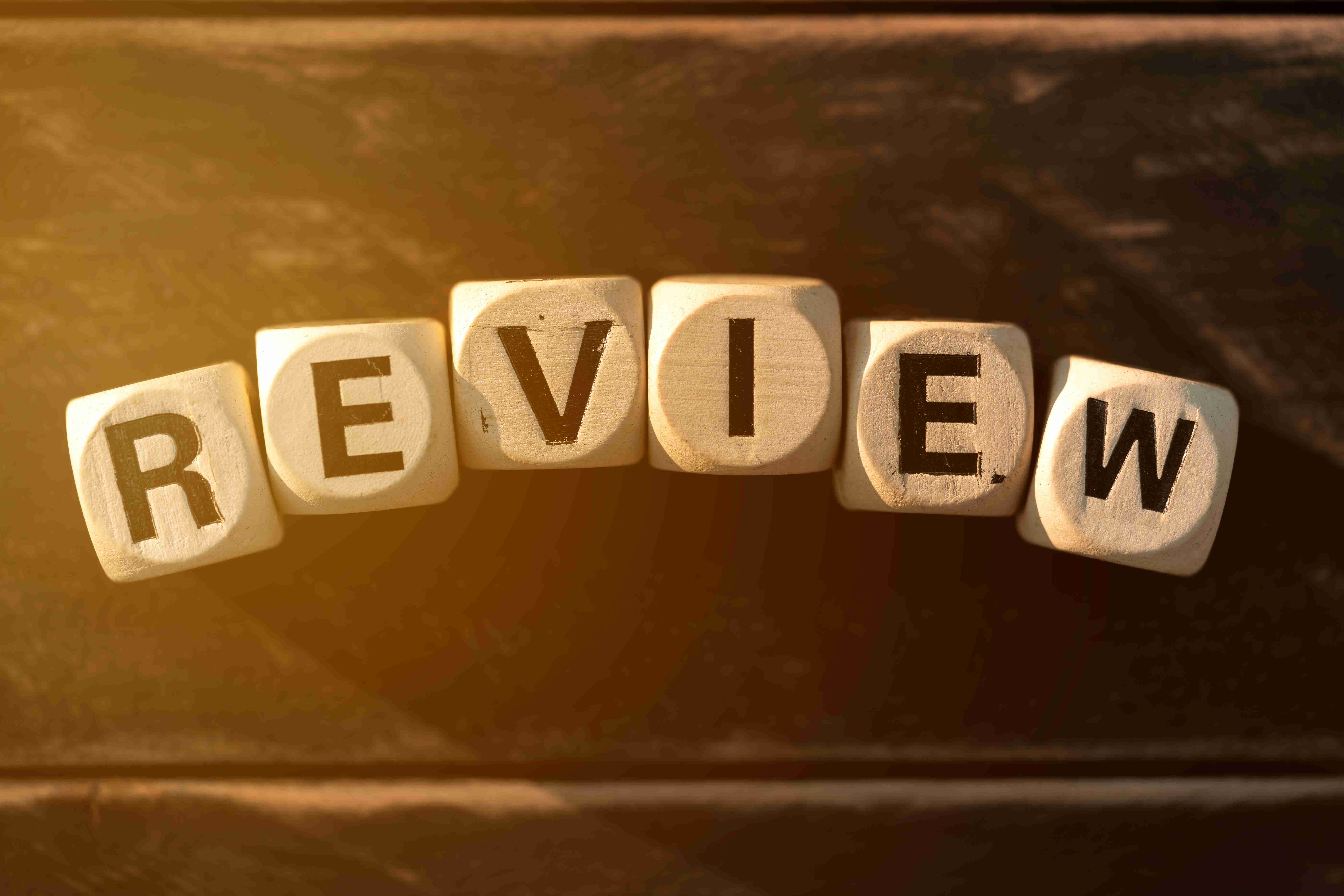 लकड़ी की मेज पर लकड़ी के ब्लॉक के साथ समीक्षा अवधारणा