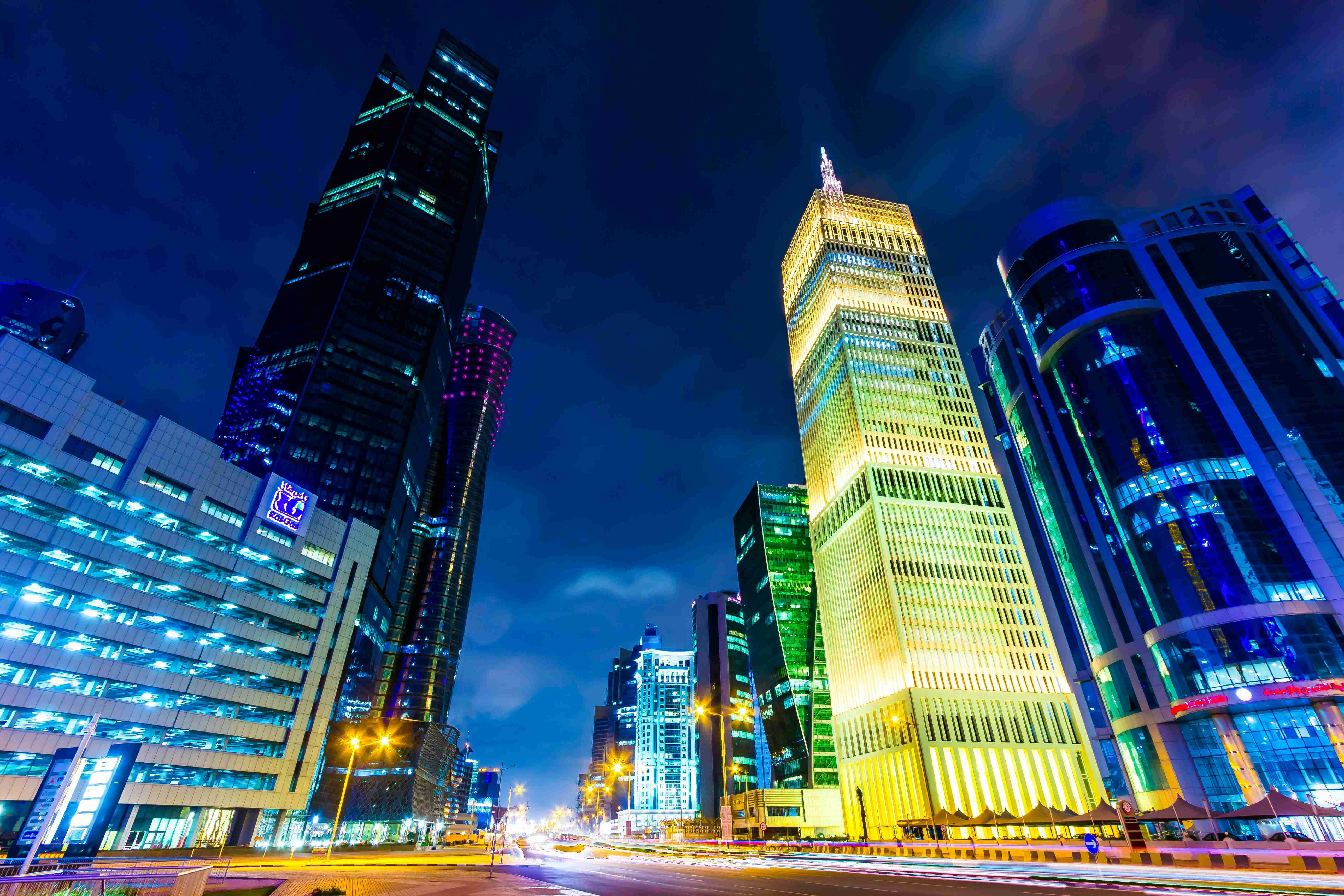 रात में ऊँची इमारतों के साथ एक शहर की सड़क