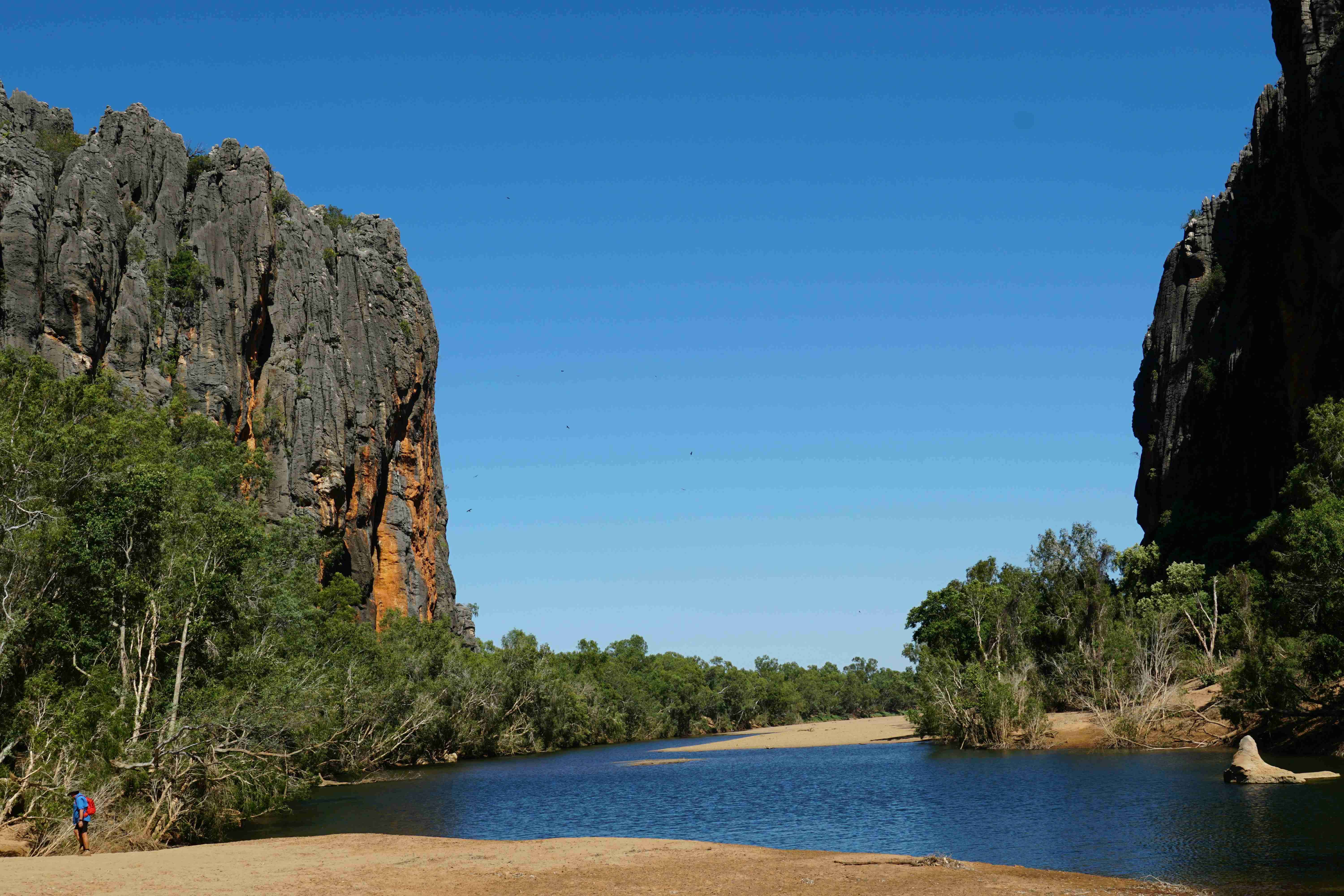 a-body-of-water-surrounded-by-mountains-and-trees