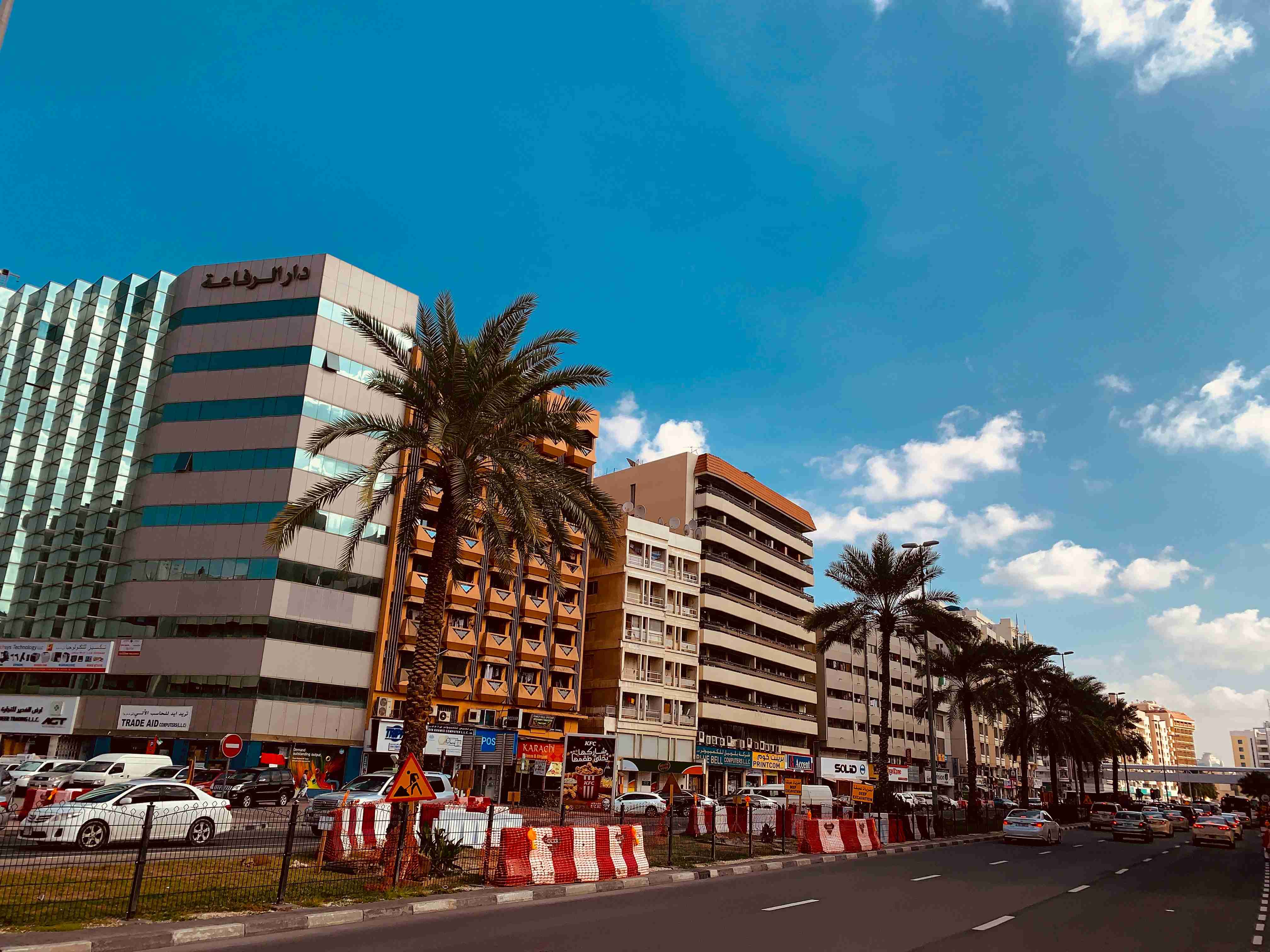 clădire din beton alb și maro lângă palmieri verzi