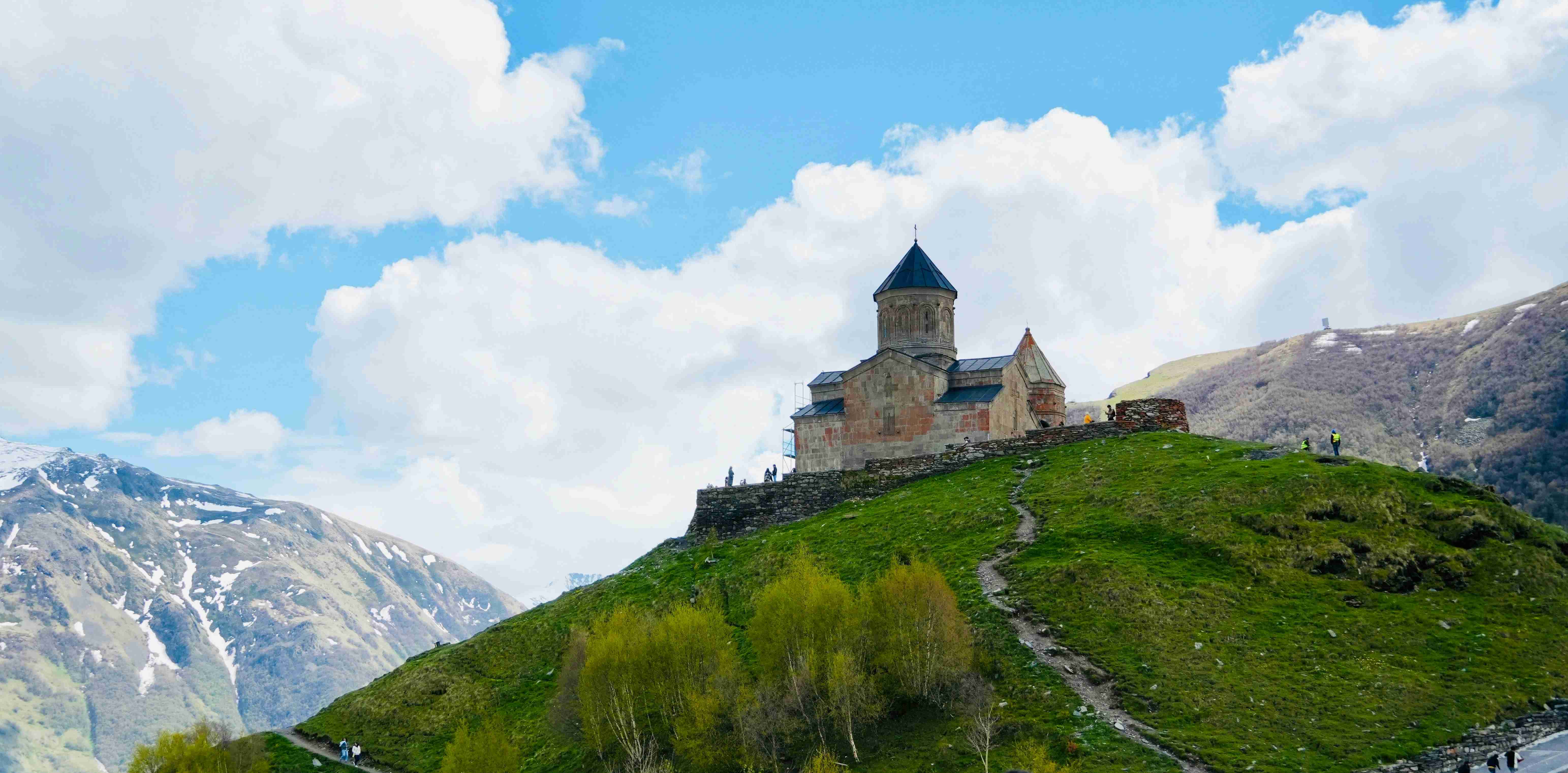 a-castle-sitting-on-top-of-a-lush-green-hillside