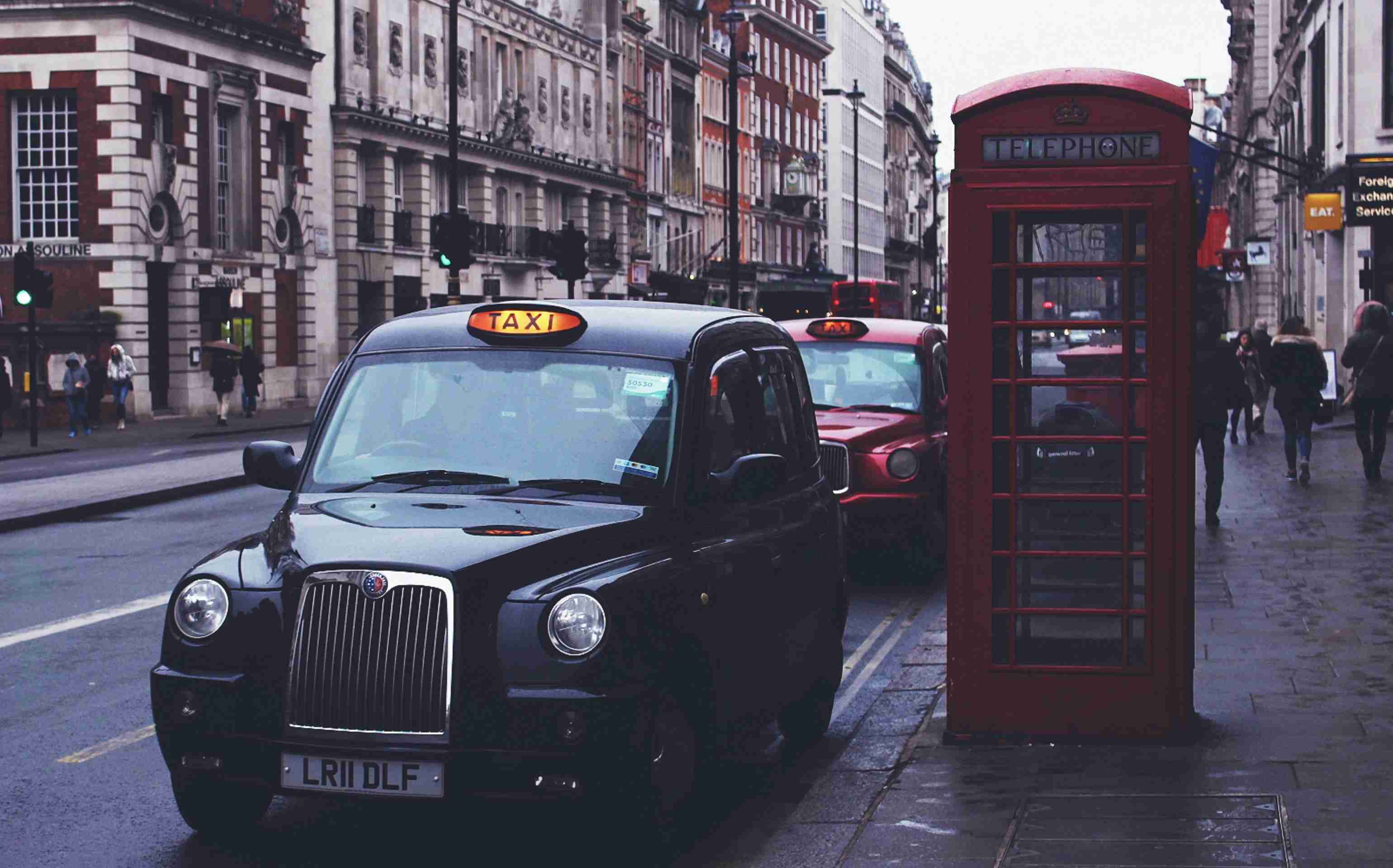 black taxi beside telephone booth