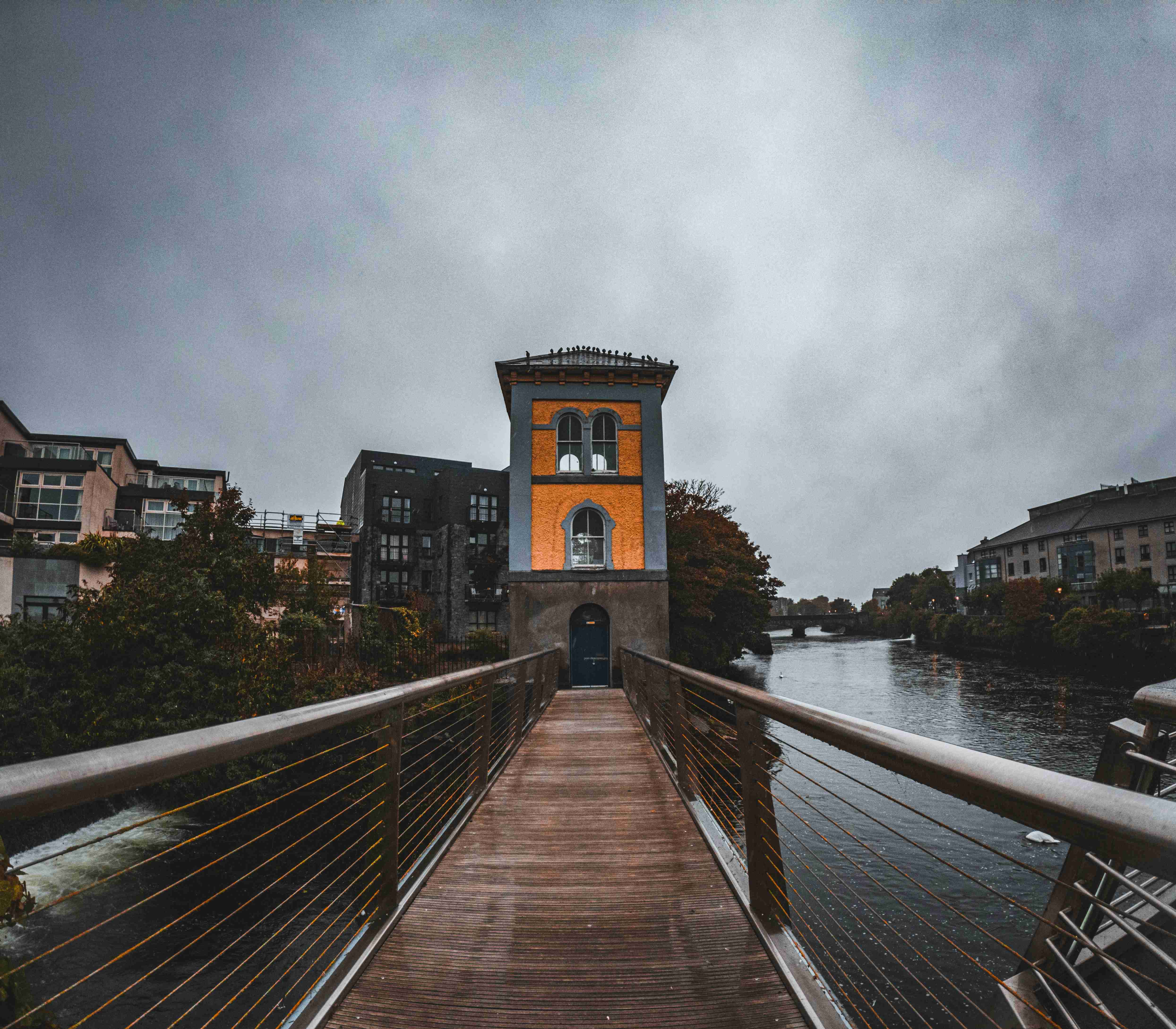a-wooden-bridge-over-water-with-buildings-on-either-side-of-it