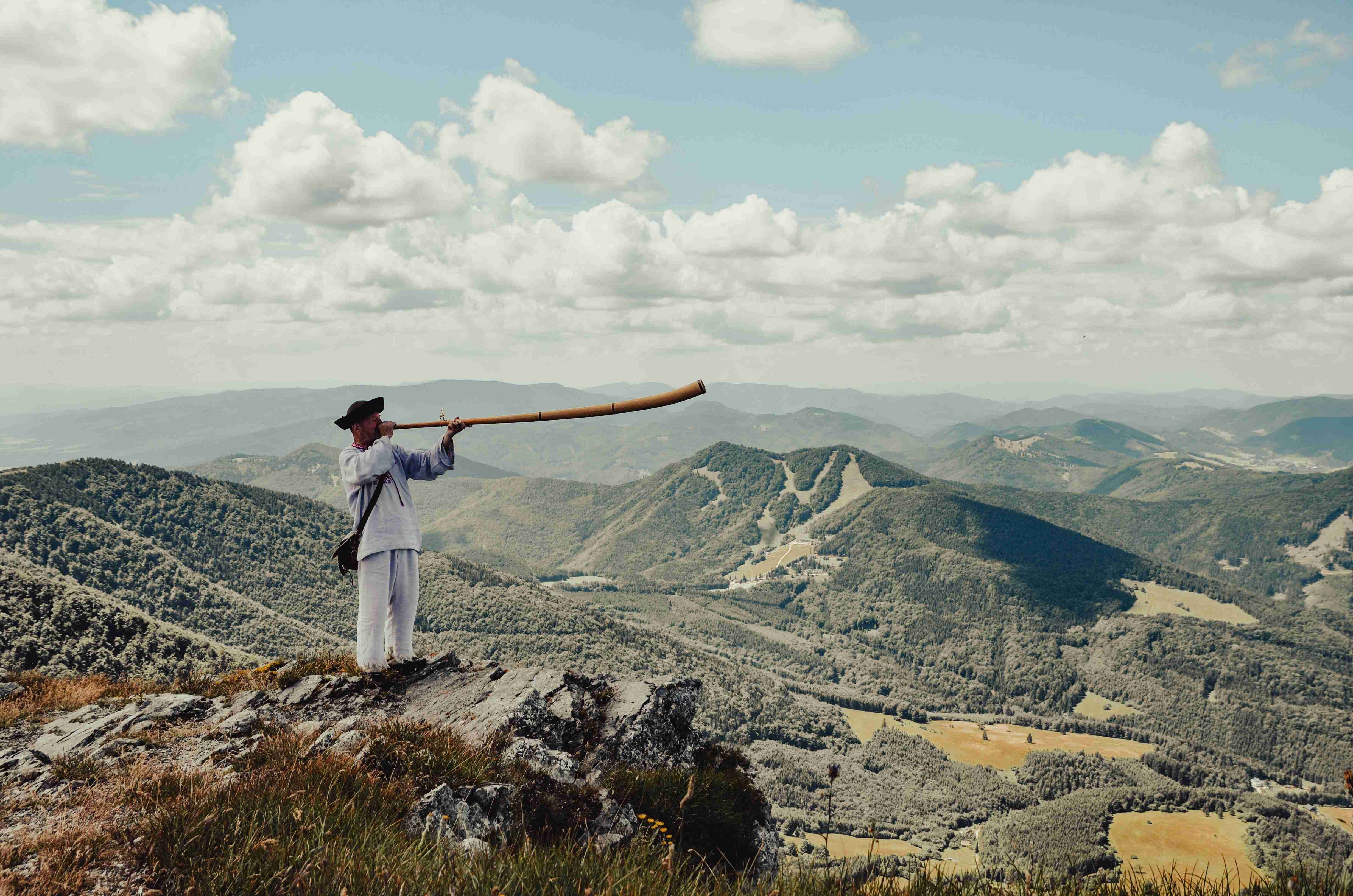 a-man-holding-a-baseball-bat-on-top-of-a-mountain