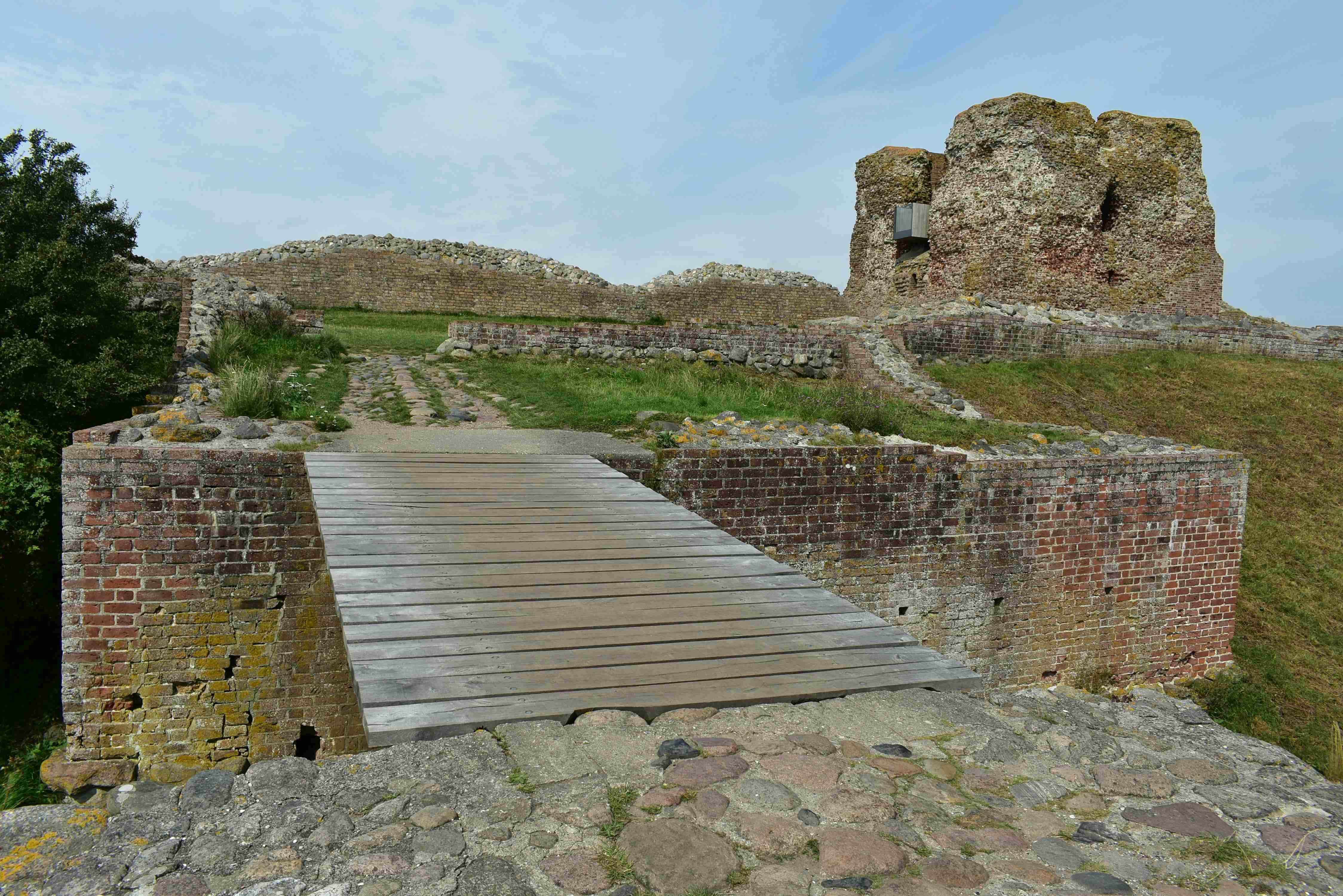 a-wooden-walkway-leading-to-a-stone-castle