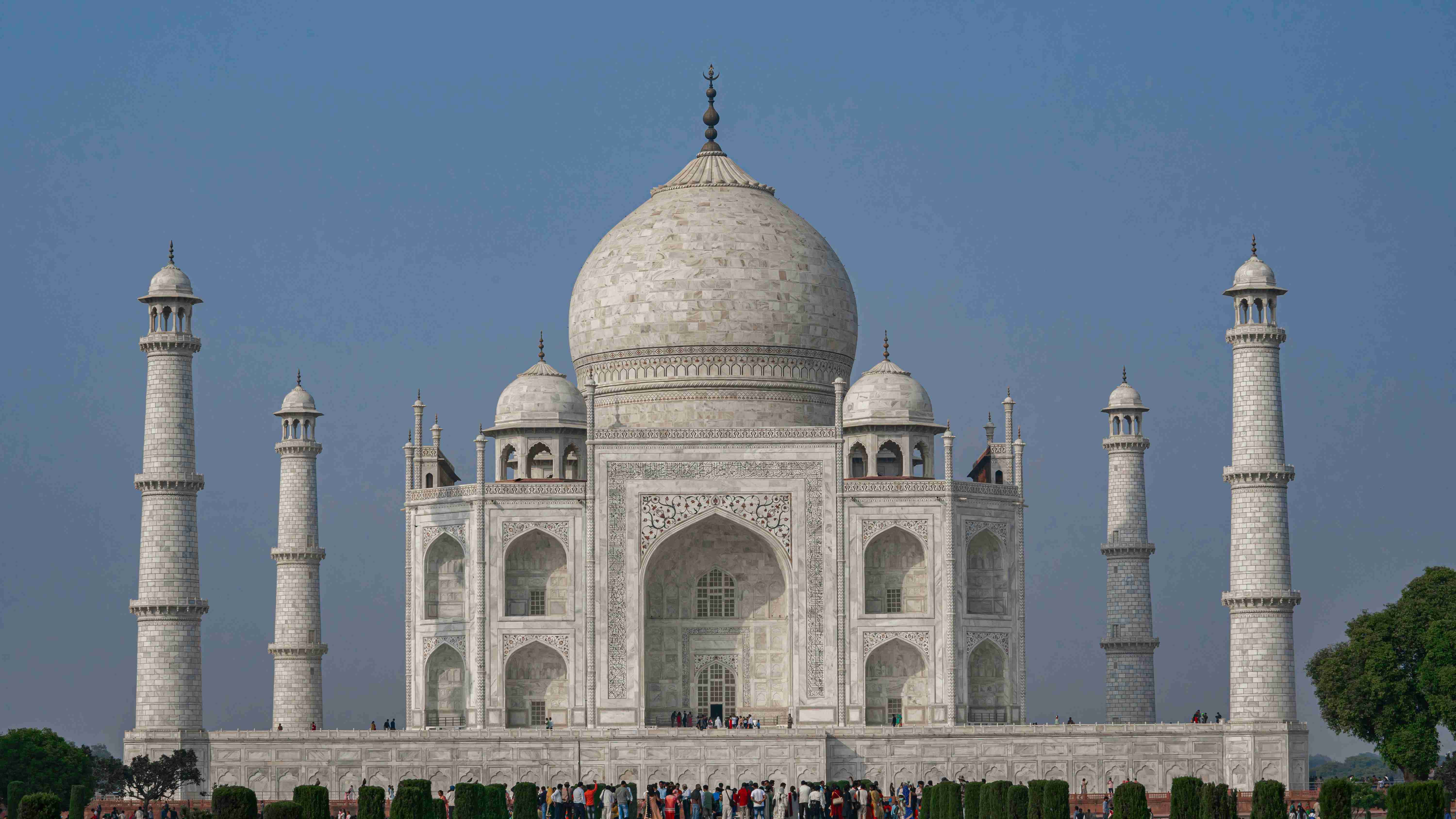 a-group-of-people-standing-in-front-of-a-white-building