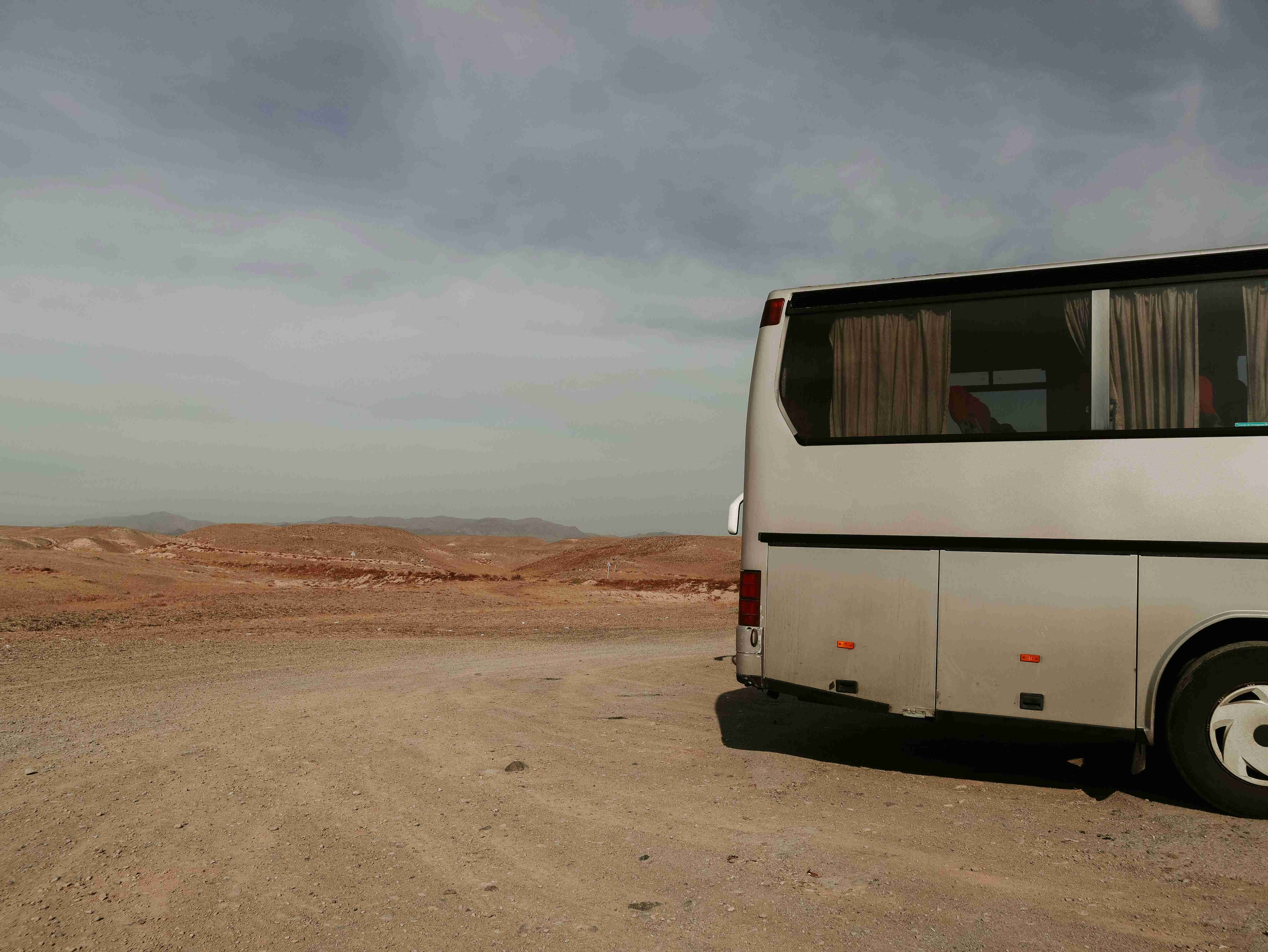 a-white-van-parked-in-a-desert