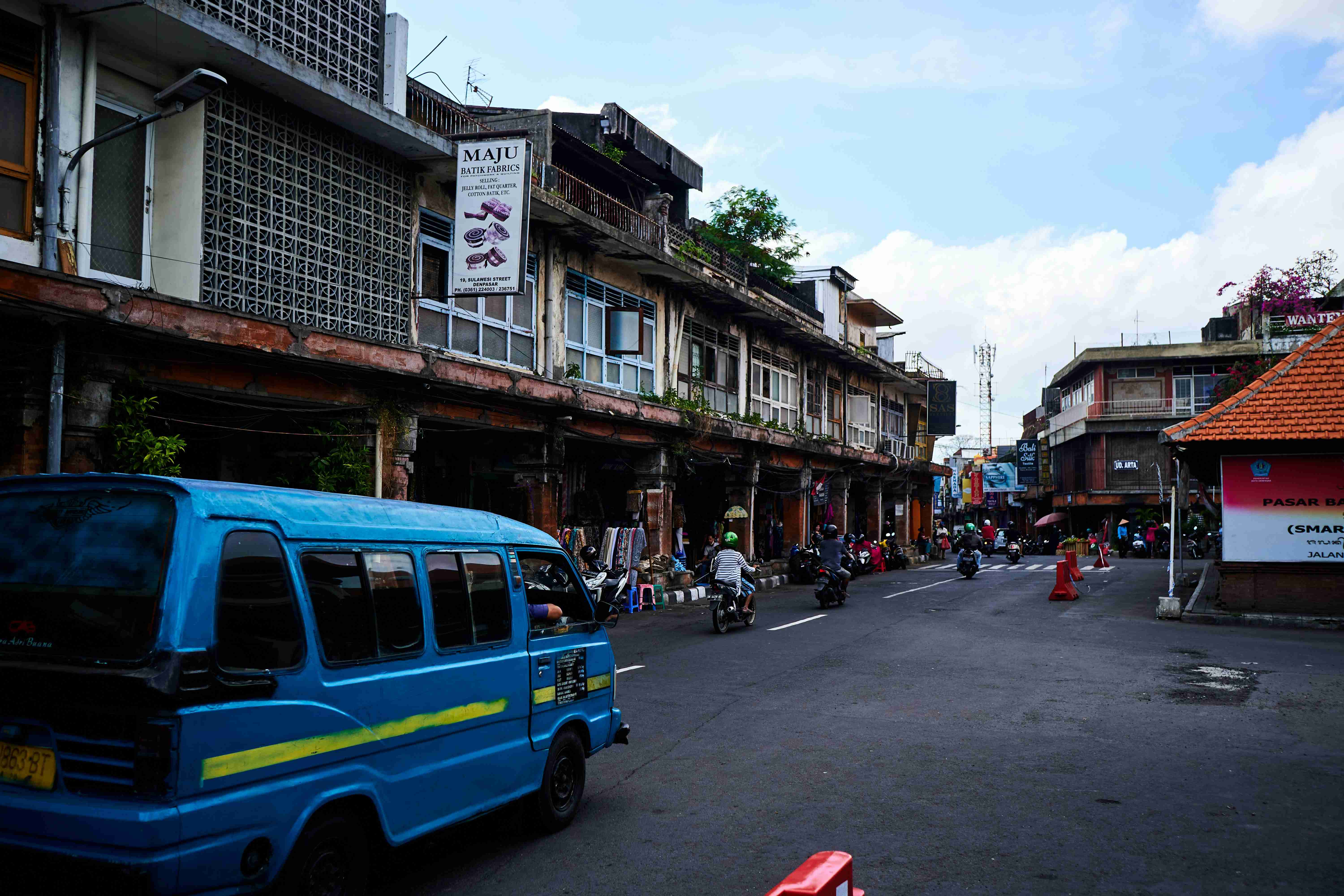blue van on road near buildings