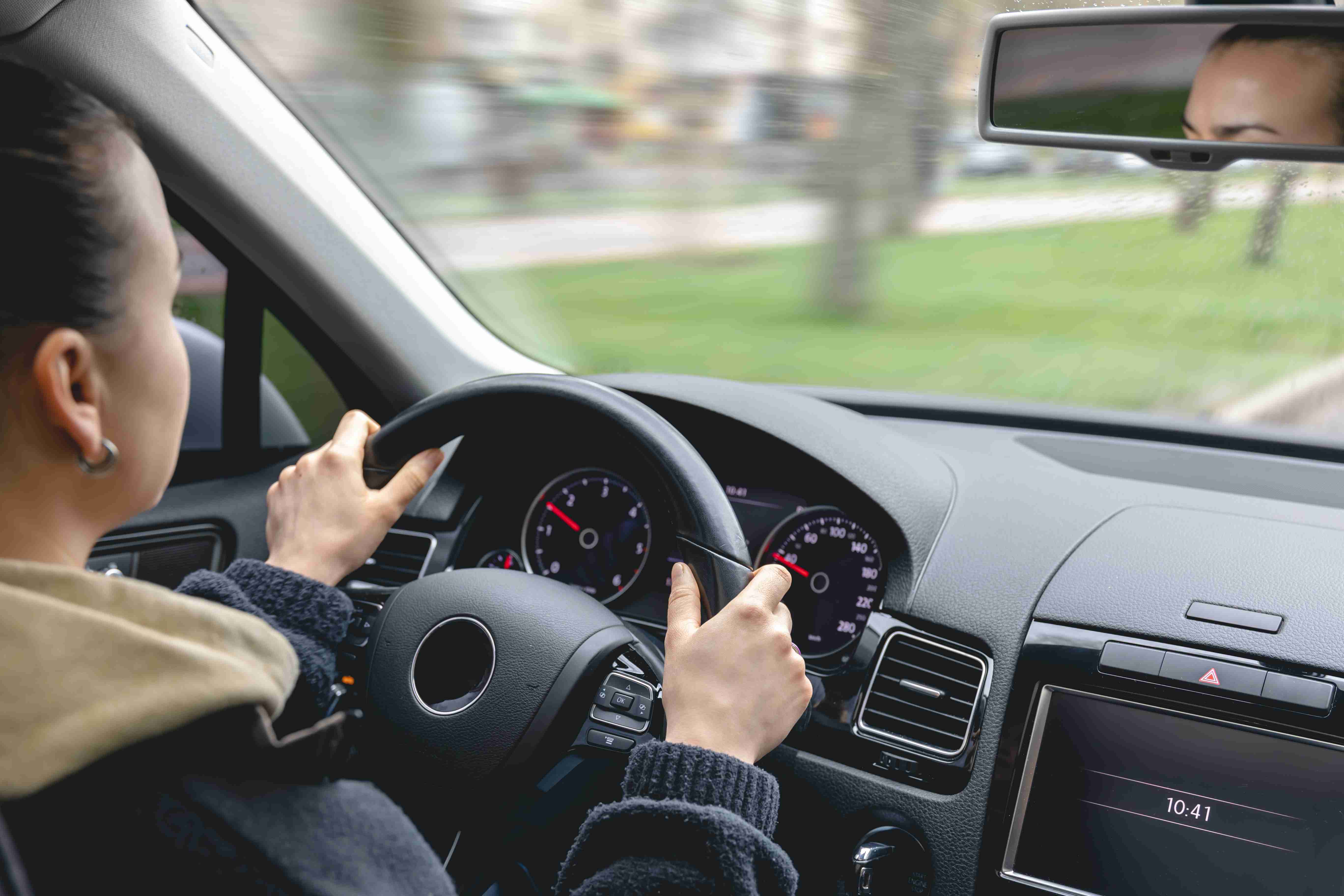 Handen van een vrouwelijke bestuurder op een autostuur