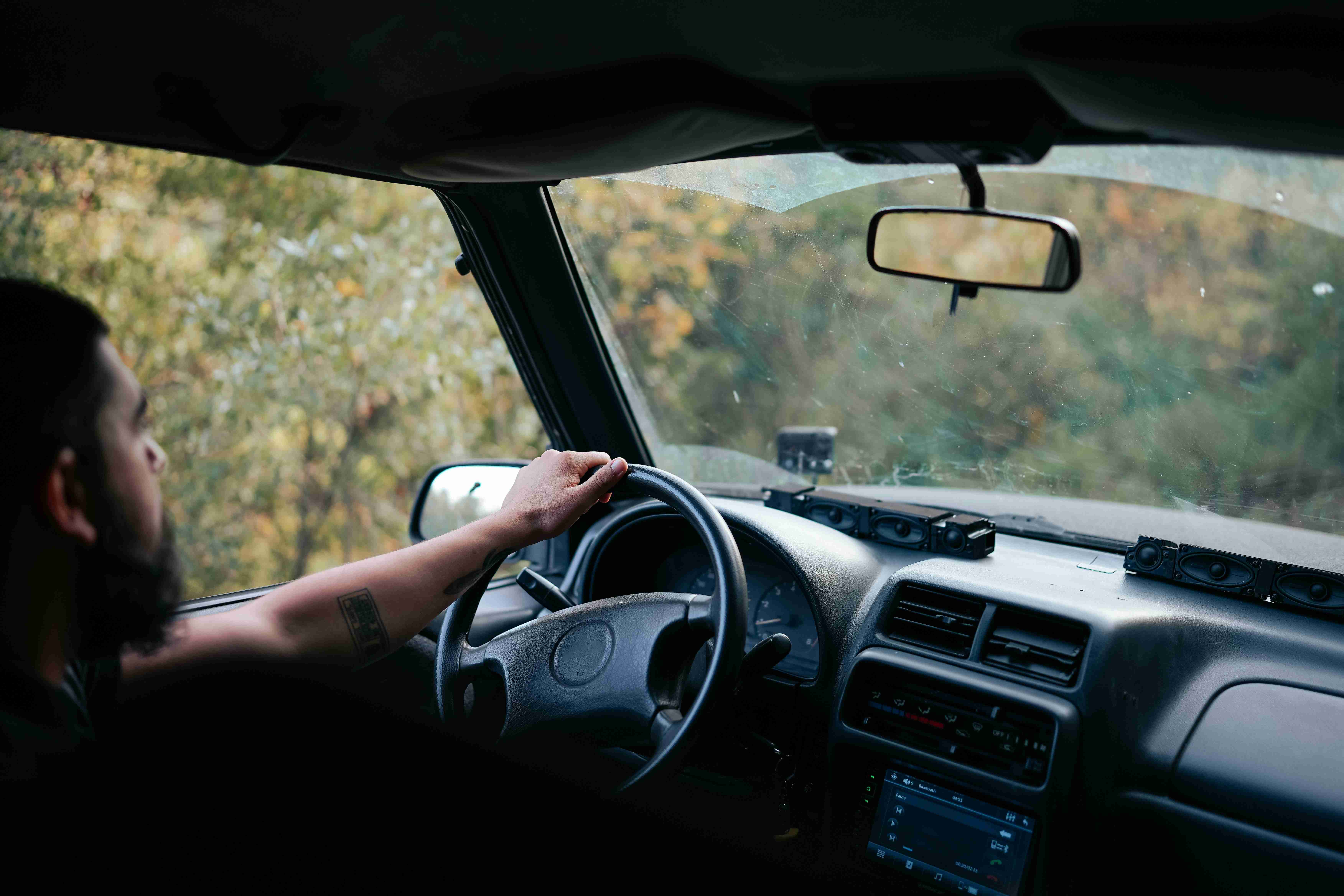 en man som kör bil på en väg
